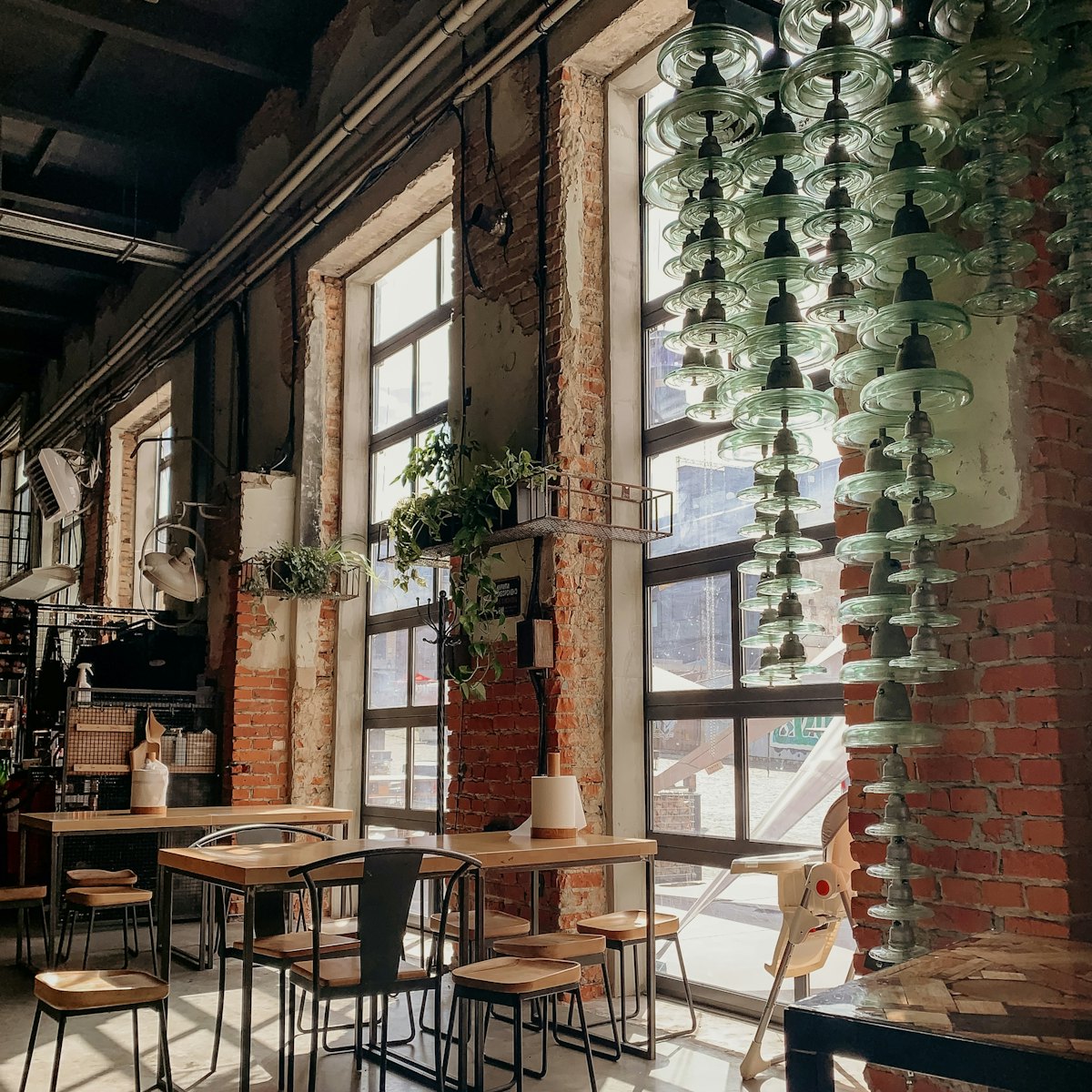 The main room with brick walls, tall windows and hanging glassware