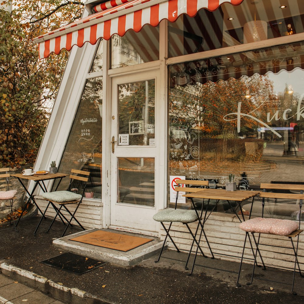 The café front under a striped awning with pavement tables