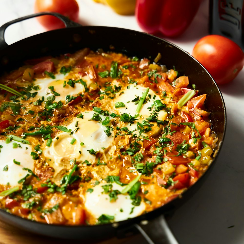 Shakshuka bubbling in a cast-iron skillet with sourdough alongside