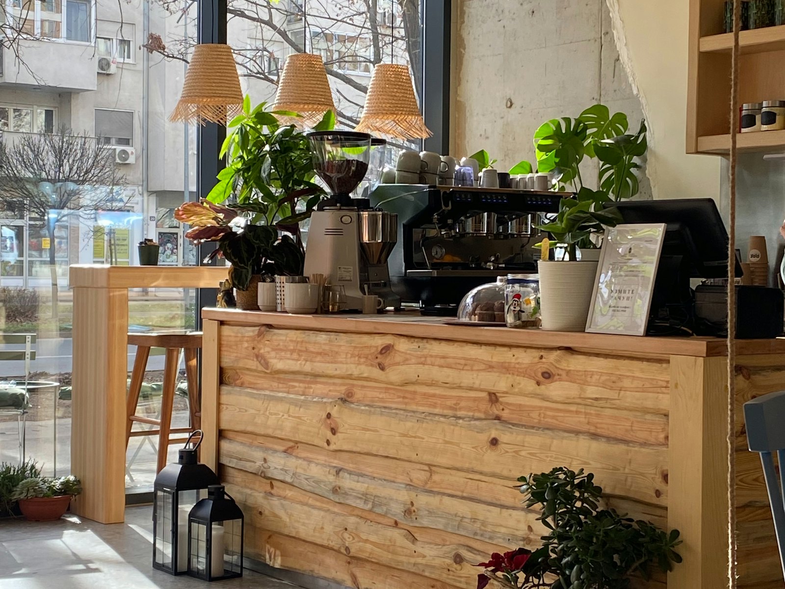 The timber coffee counter with plants and rattan pendant lamps