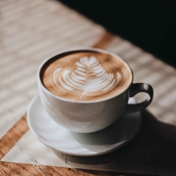 White cup and saucer on a brown wooden table