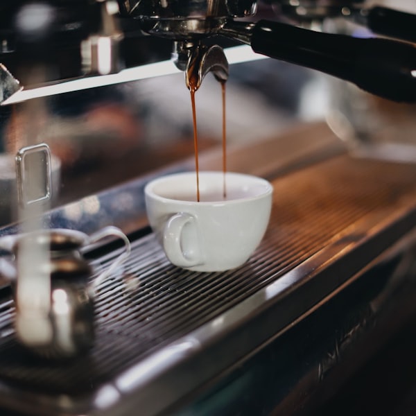 Espresso running from the machine into a white cup