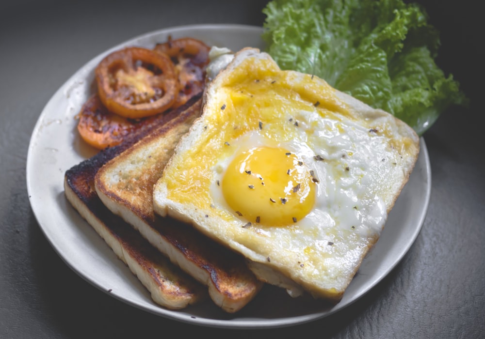 Breakfast plate of toasted sourdough with a fried egg and grilled tomato