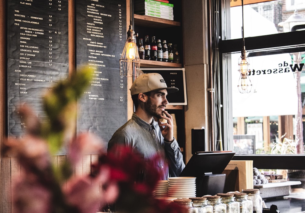 A customer ordering at the counter beneath the chalkboard menu