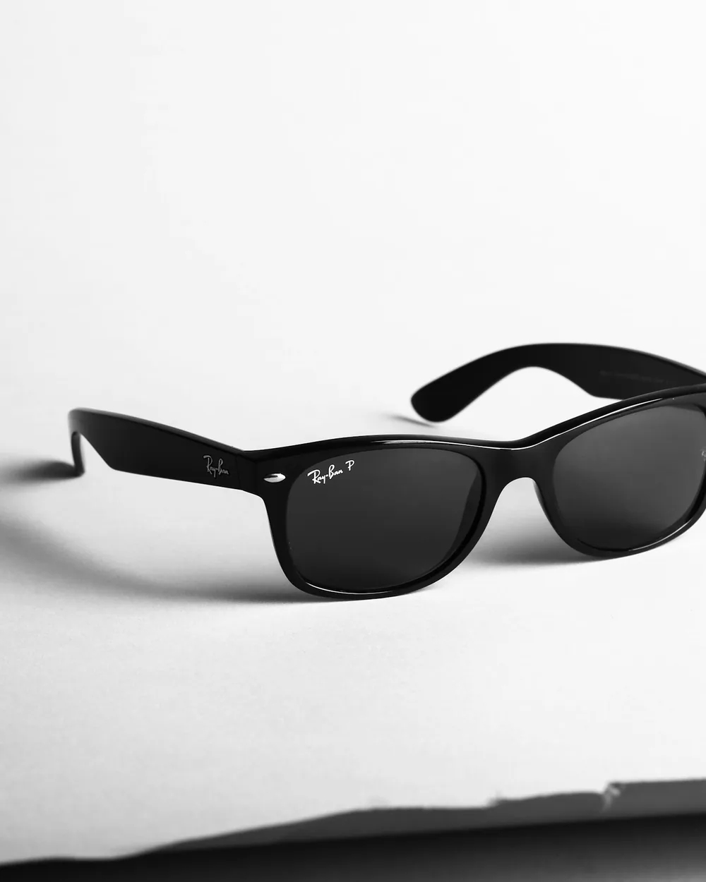 Black sunglasses photographed as a high-contrast still life