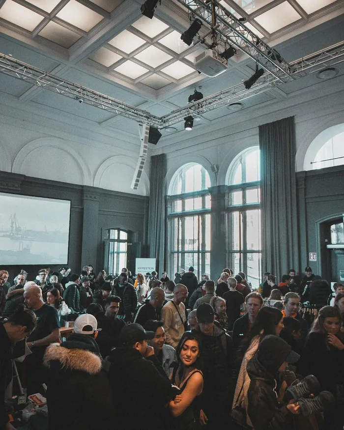Guests mingling in a daylit hall before a keynote