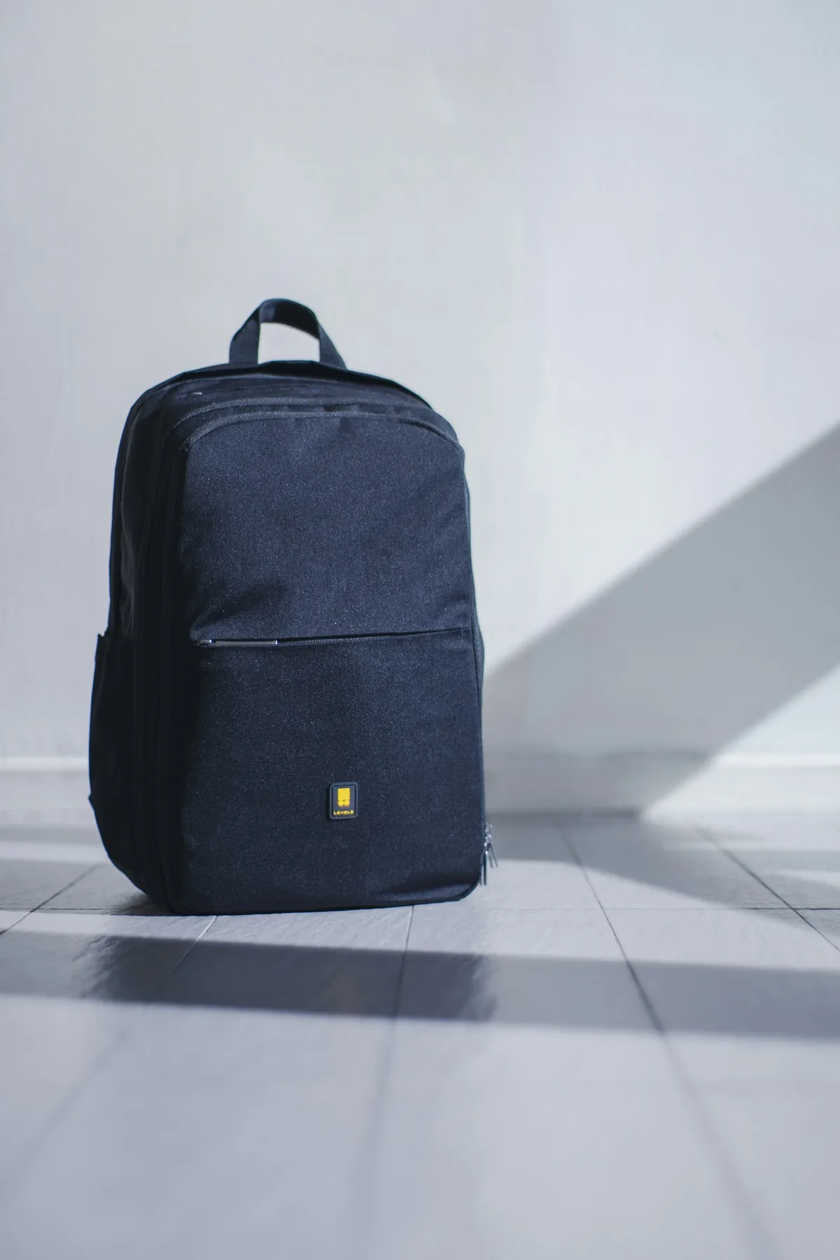 Navy backpack lit by hard window light