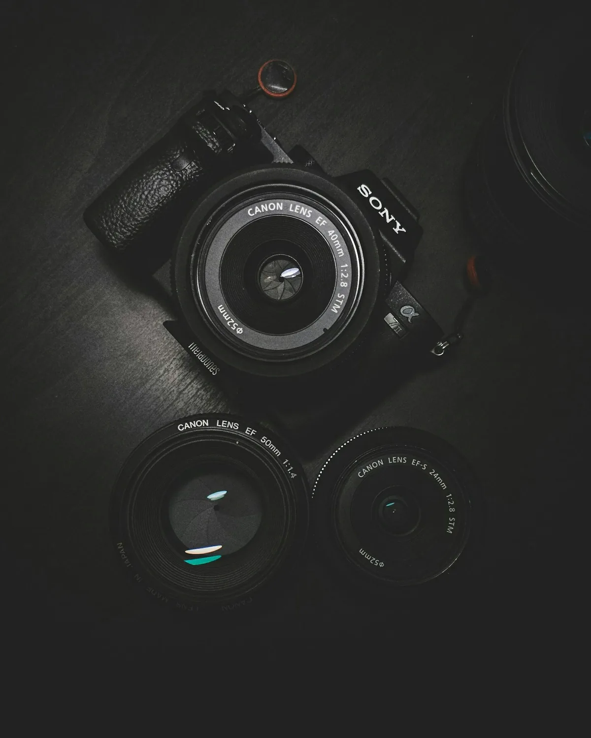 Camera body and prime lenses laid out on black