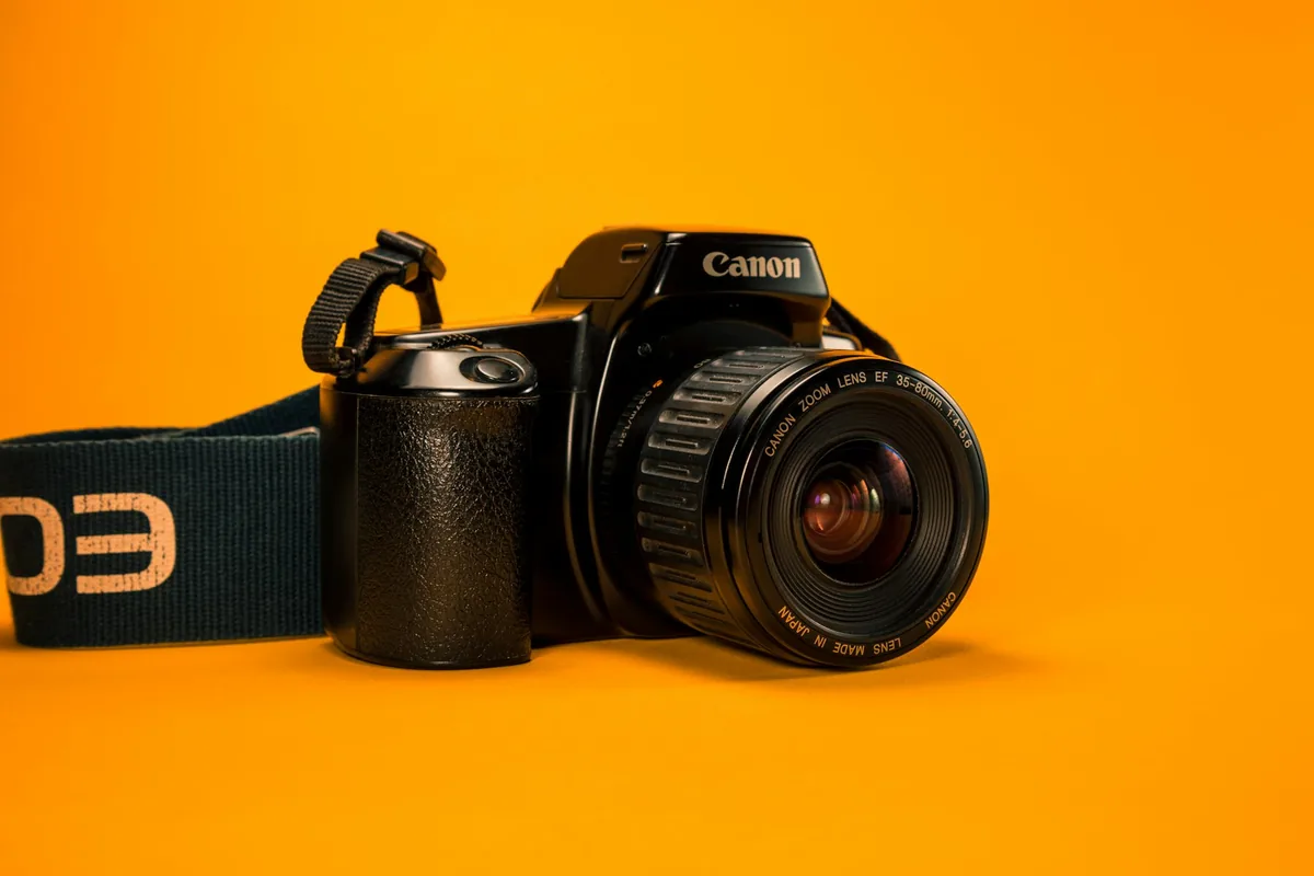 DSLR camera on a bright orange background