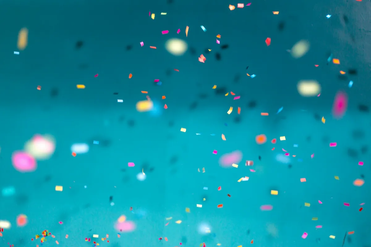 Confetti suspended against a teal background