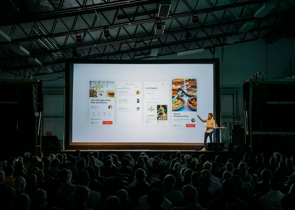 Speaker on stage in front of a large presentation screen