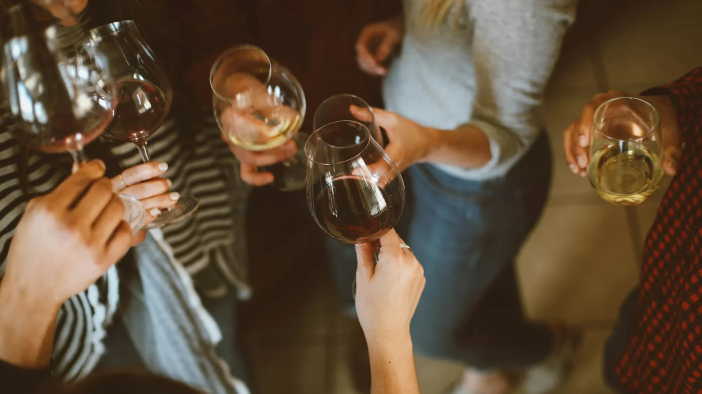 Guests raising glasses in a warm candlelit toast