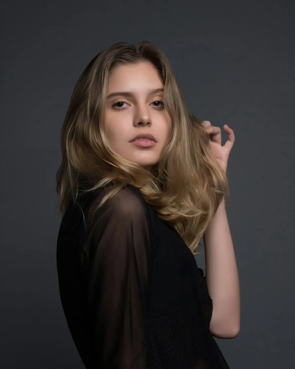 Low-key studio portrait of a woman in sheer black