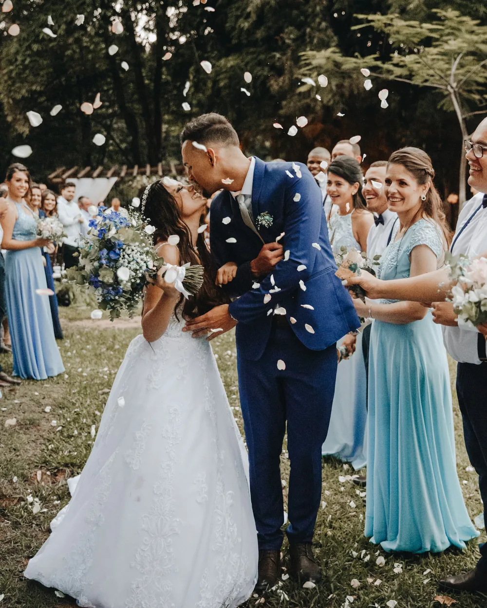 Couple kissing as guests throw confetti after the ceremony