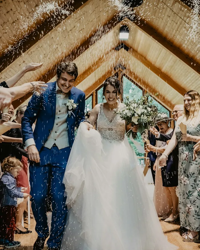 Bride and groom walking back down the aisle through applause