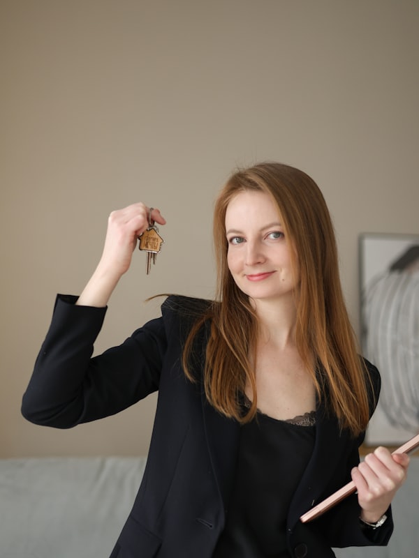 A consultant in a dark suit holding a set of keys and a clipboard during a site visit