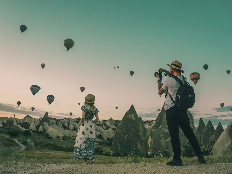 Photographer watching hot air balloons at sunrise