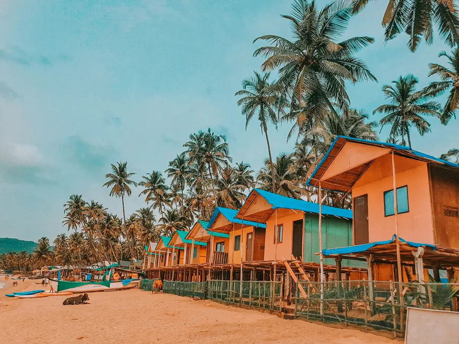 Palm-fringed beach huts on the sand in Goa