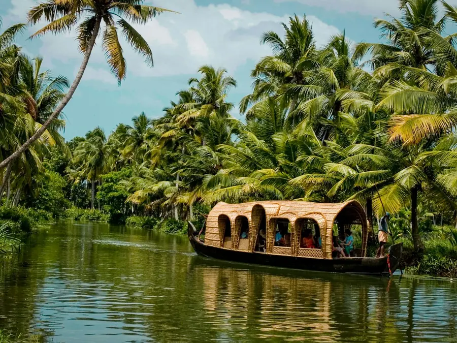Houseboat drifting through palm-lined Kerala backwaters