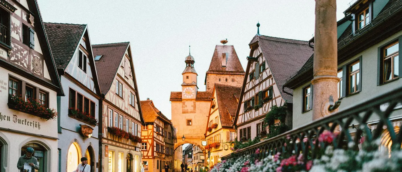 Alpine village square with timber houses and flowers
