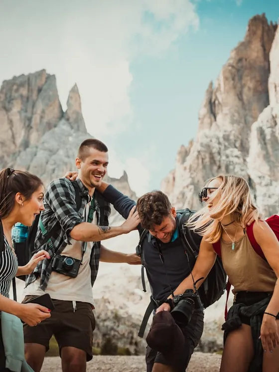 Group of friends hiking together beneath dramatic peaks