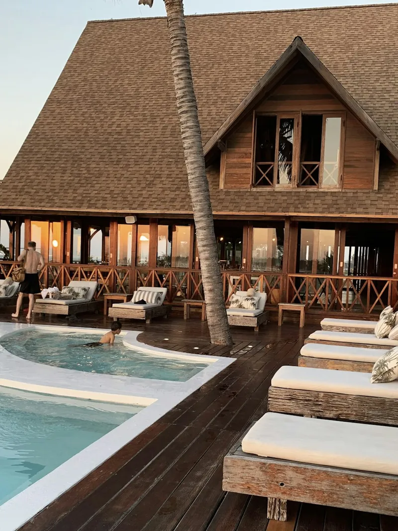 Luxury villa pool and loungers beside a tropical garden