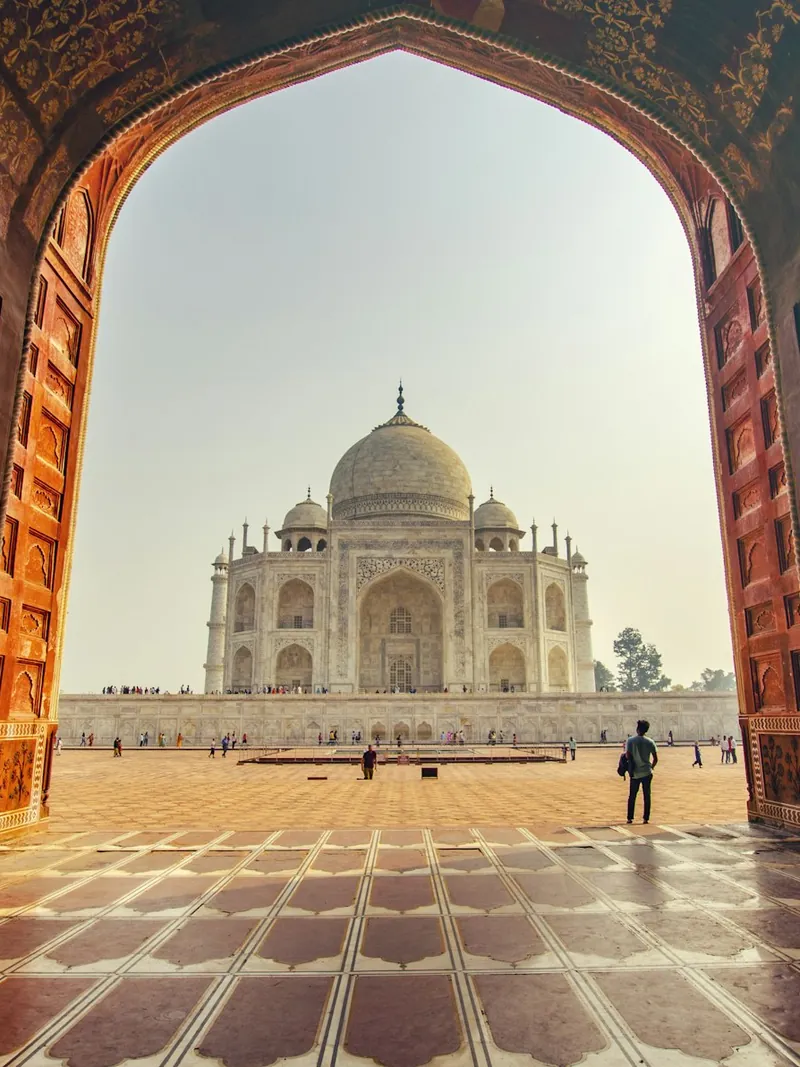 The Taj Mahal framed through a sandstone gateway
