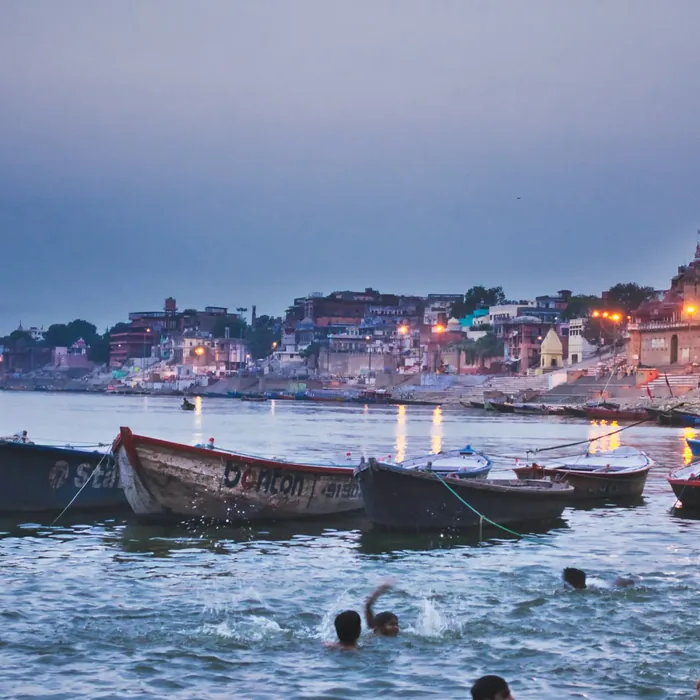Wooden boats moored along a river ghat at dawn