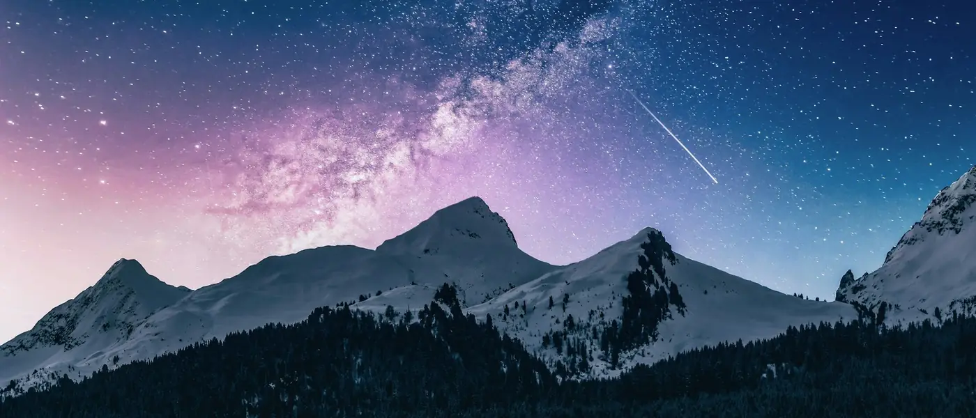 Starry night sky above a silhouetted mountain range