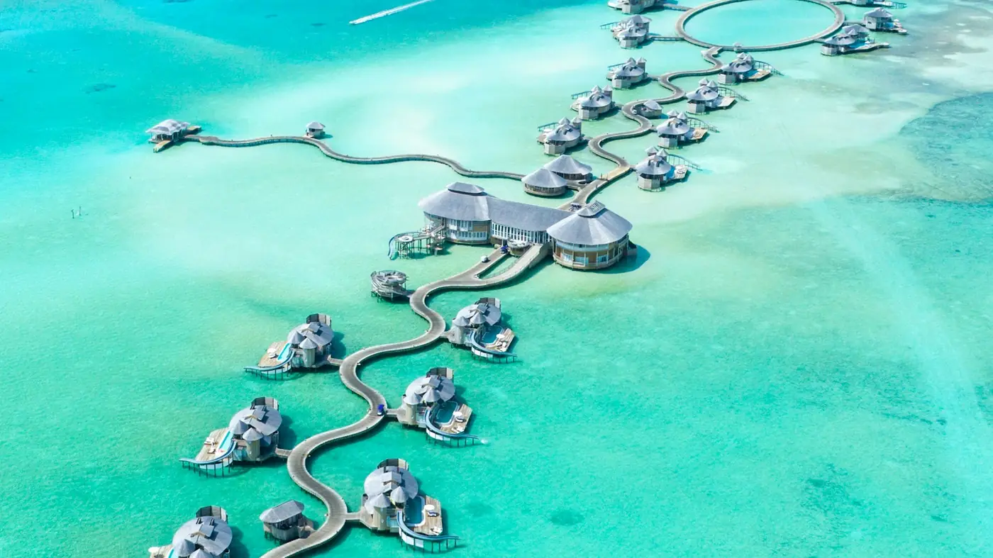 Overwater villas curving across a turquoise lagoon