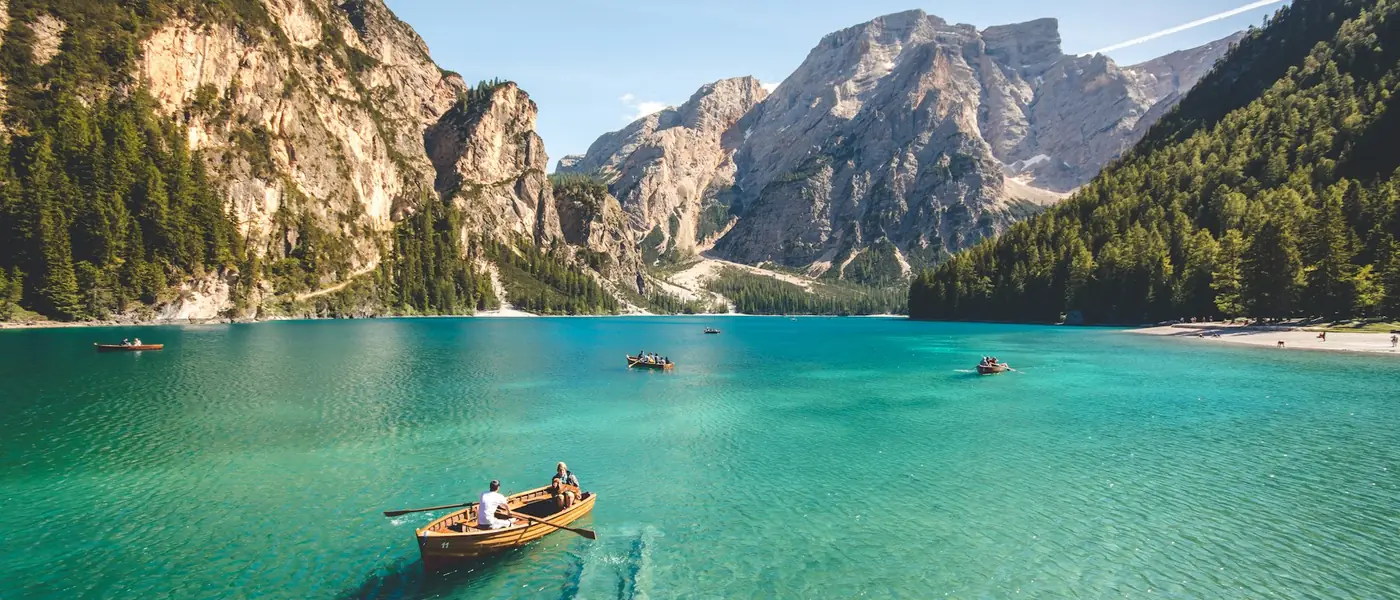 Wooden boat on an emerald alpine lake ringed by mountains